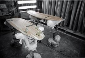 Zwei Sunova Surfboards auf Ständern zum Trocknen in der Fabrik.