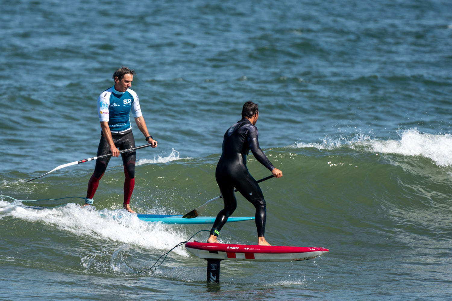 Kai Steimer auf einem Fanatic Foil SUP Board und Thomas Wendt auf einem Fanatic Stylemaster Wave SUP Board teilen sich eine Welle.