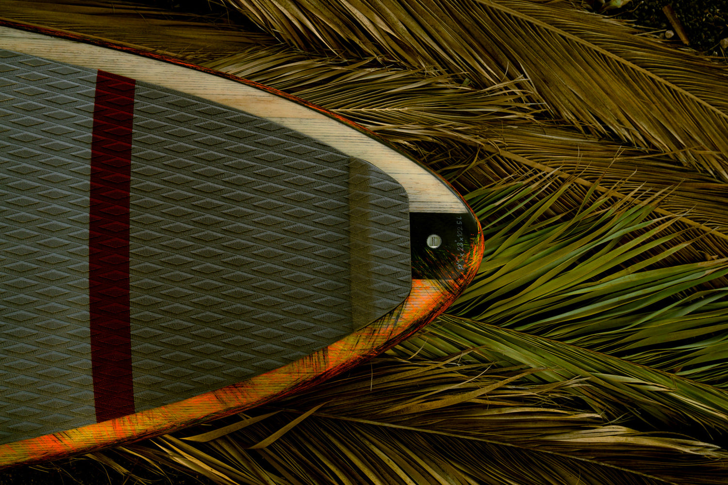 Heck des Sunova Flash Wave SUP Board auf Palmwedeln.