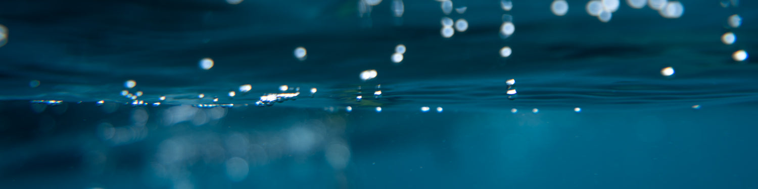 Unterwasserfoto von Wasserbläschen an der Wasseroberfläche.