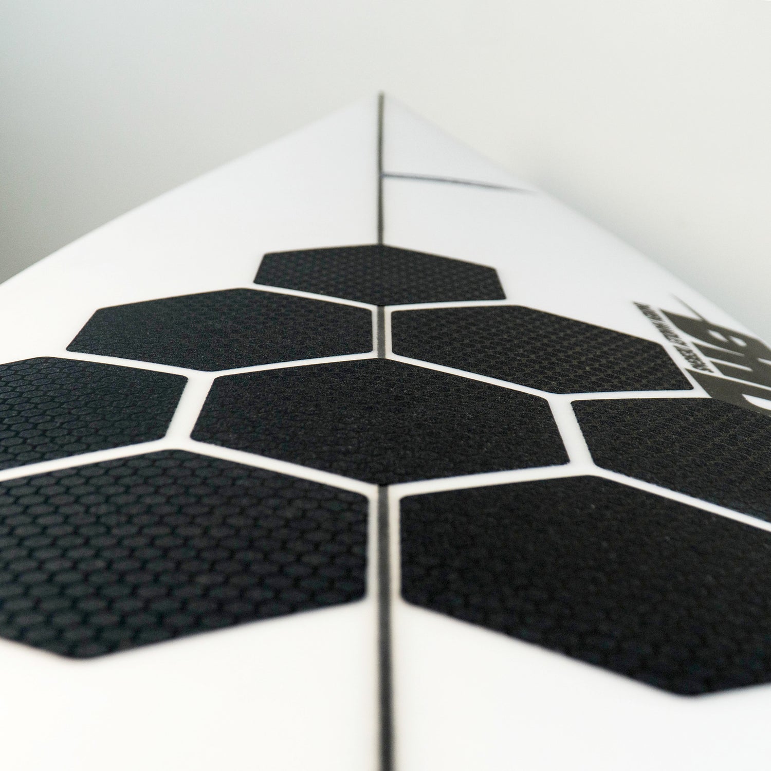 Perspektivische Detailansicht der RSPro Hexa Traction in Schwarz auf einem Surfboard.